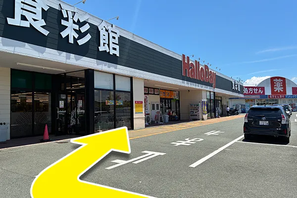 食彩館看板下を建物沿い右方向へ進みます。
